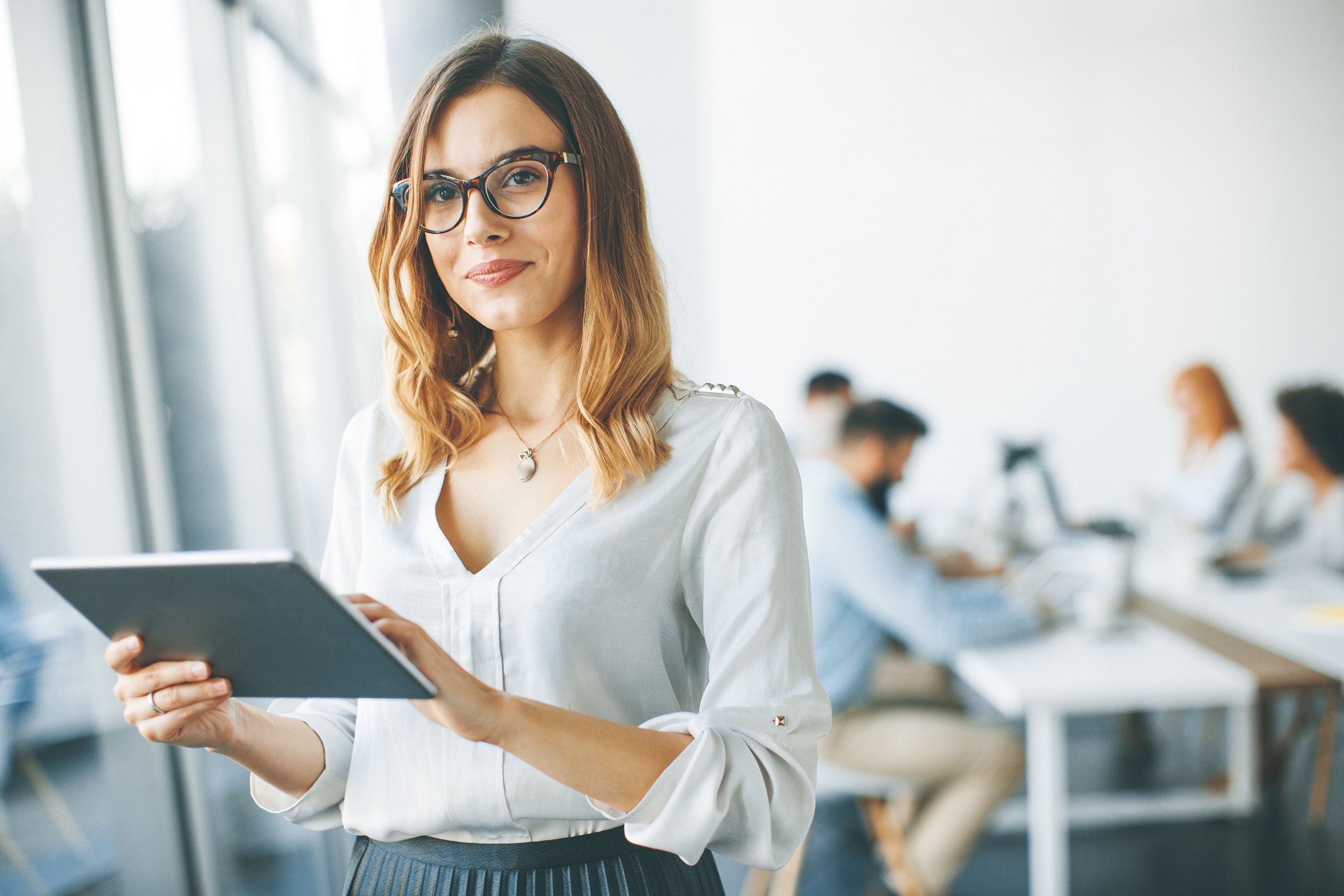 Elegant businesswoman standing in office with digital tablet CFO Advisory